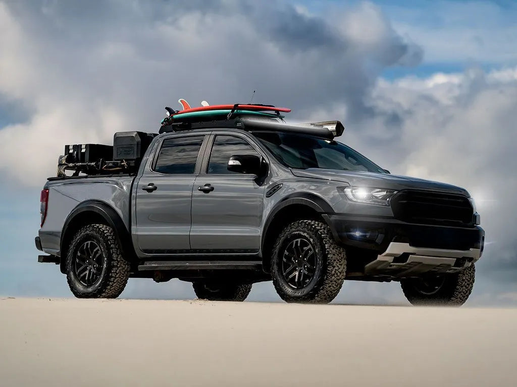 Gray pickup truck with surfboards on a beach