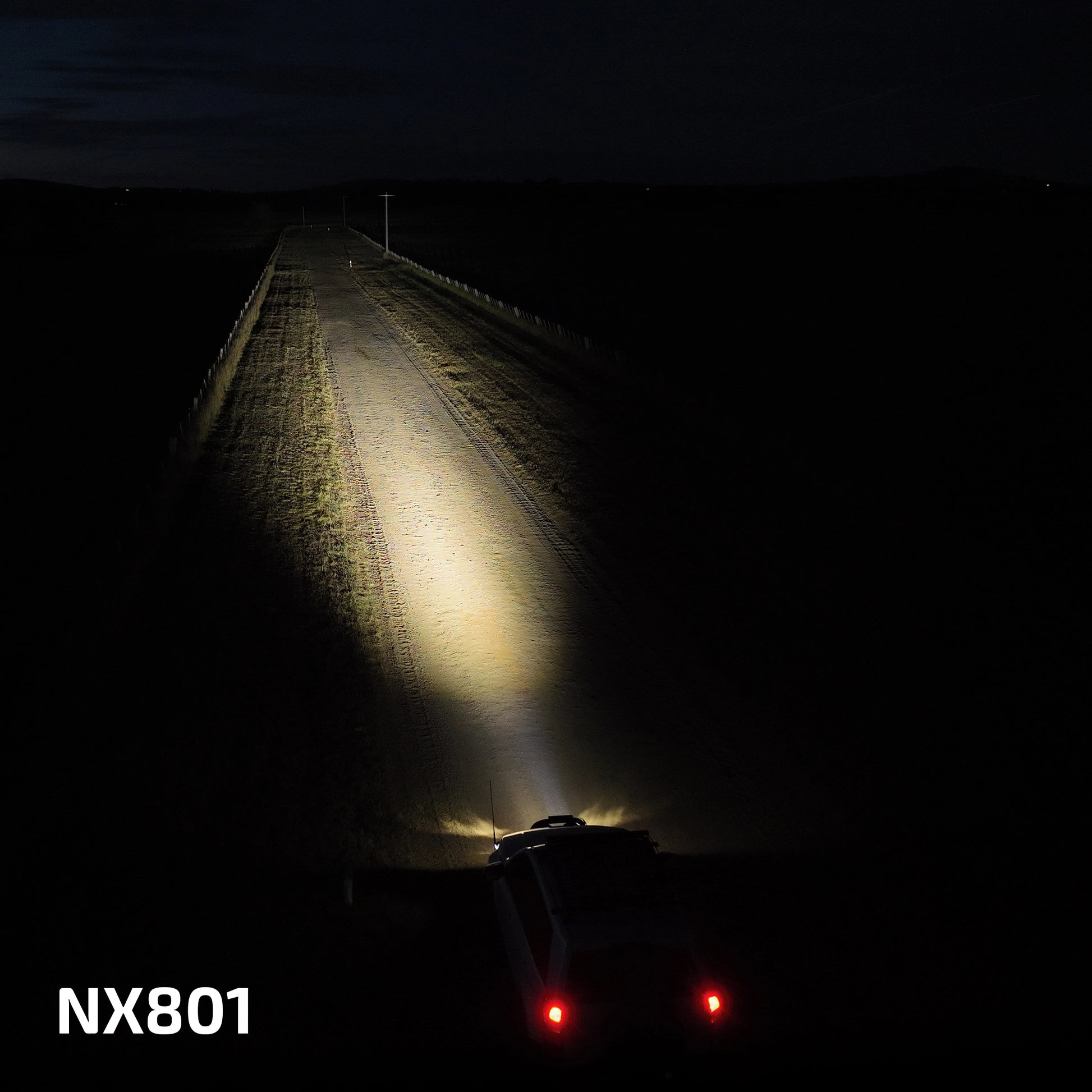 Car driving on a dark road with headlights illuminating the path, featuring the brand 'NX801'.